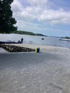 on the pier looking out on the lake, boats and a waterbus are on the lake