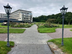 two grey lamposts light the path up to a building