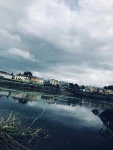 A view of a body of water and with houses in the background